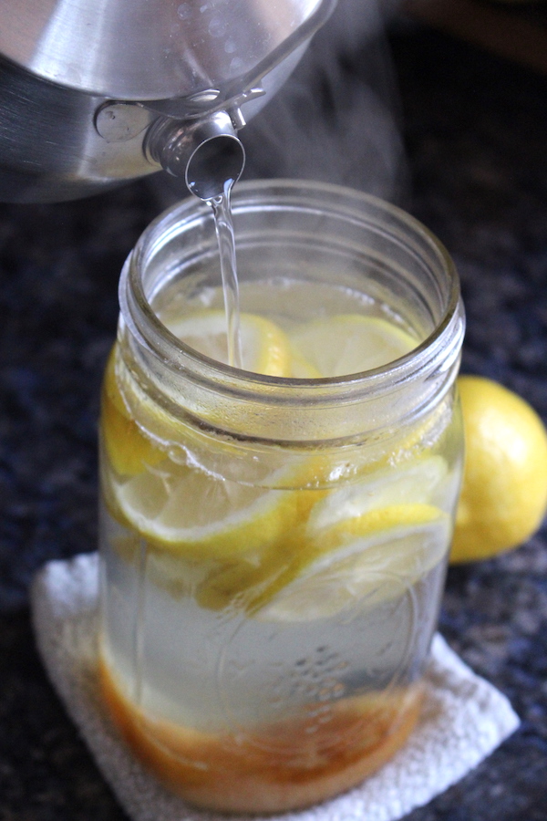 Pouring hot water over honey and lemons to make sima, a type of lemon soda