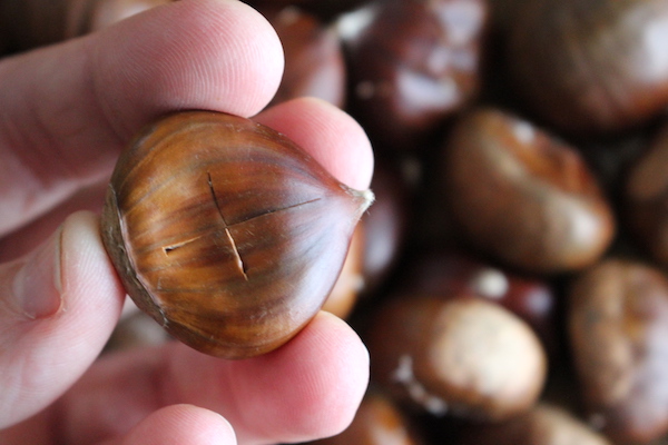 Slicing an "X" on the chestnuts before roasting them gives steam a way to escape, and makes them easier to peel.