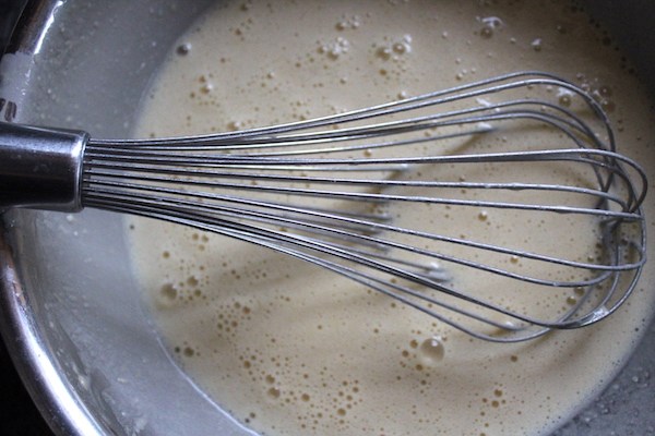 Whisking dutch baby batter with a balloon whisk.