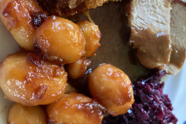 Browned potatoes with brown gravy, pork roast and red cabbage