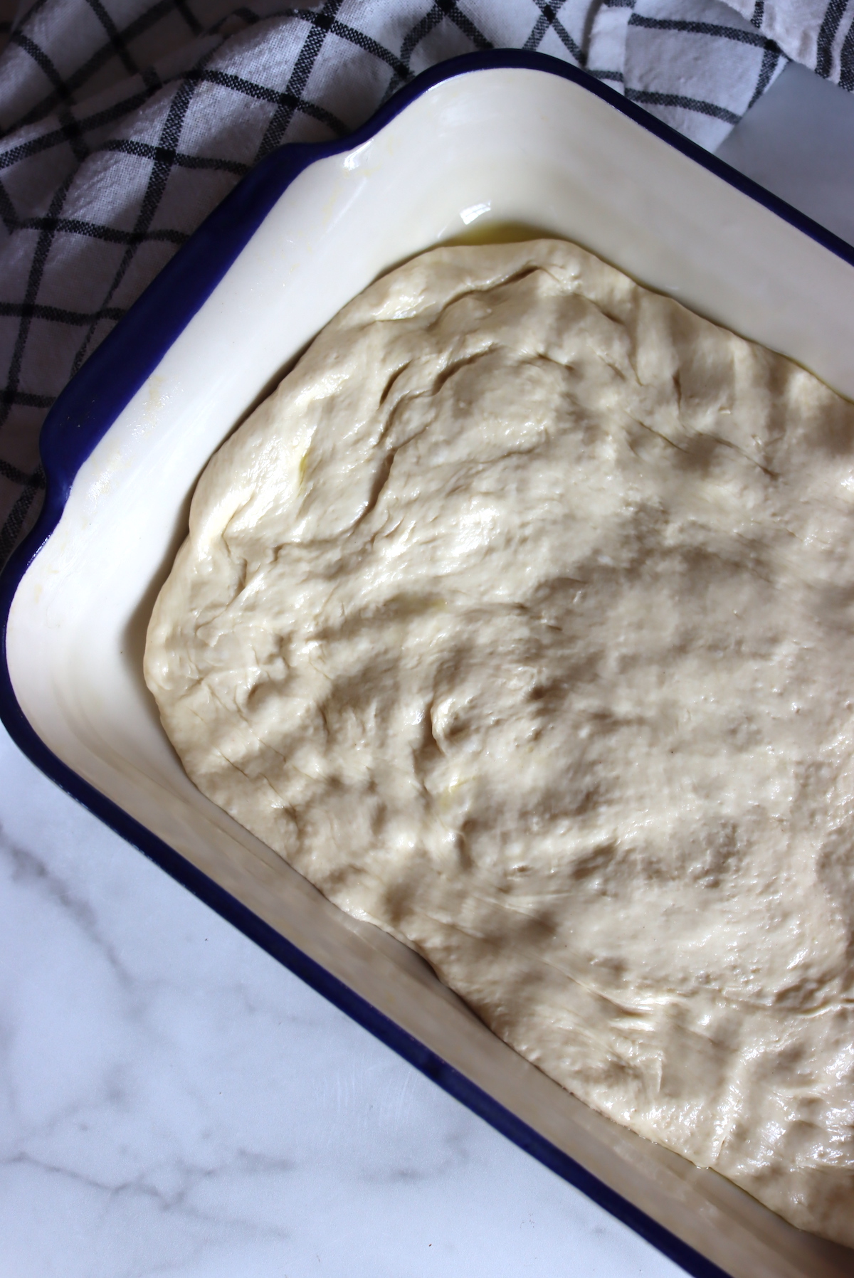 Bread Machine Focaccia dough pressed out into a baking pan