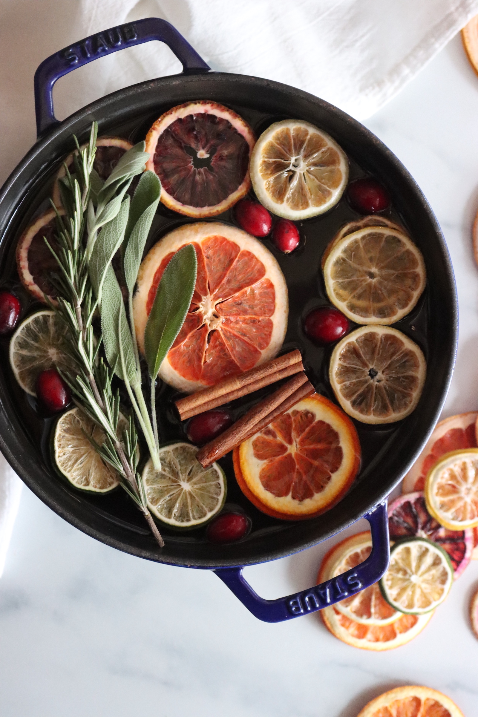 How to make a simmer pot with dried citrus slices, cranberries, cinnamon sticks, rosemary, and sage